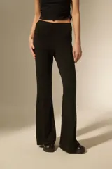Pantalón tipo calza de tiro alto con corte flare, confeccionado en tejido de viscosa y elastano con detalles de strass dispersos.