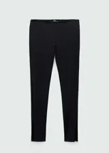 Leggings negros de corte entallado con aberturas en el bajo y detalle de puntilla en la cintura. Cuentan con cierre lateral invisible.