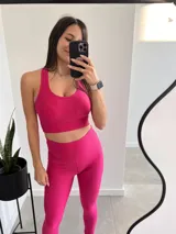 Top deportivo fucsia de lycra con breteles anchos y espalda deportiva.