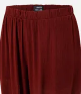 Pantalón estilo aladino color bordó, confeccionado en tejido crepé con textura. Presenta cintura elástica, corte holgado en las piernas y ruedo ajustado con lazo decorativo.