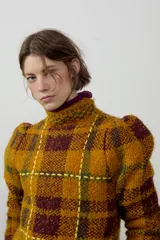 Jersey de punto con cuello perkins y manga larga, diseño a cuadros en tonos mostaza y marrón con detalles de costuras en color amarillo neón.
