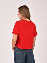 Remera negra de manga corta con estampado frontal que dice "WEST COAST California" en blanco y detalles gráficos en las mangas.