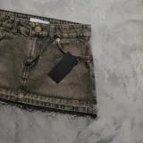 Minifalda de denim con efecto acid wash en tonos marrón y gris, diseño de tiro alto, bolsillos delanteros y ruedo desmechado.
