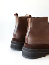 Bota corta de cuero en tonos chocolate, con diseño de paneles texturizados y suela track robusta de goma.