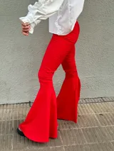 Pantalón negro de tiro alto con corte acampanado y terminación en volado en el ruedo.