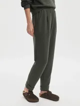 Pantalón de jogging color verde oliva, confeccionado en tejido DoubleSoft®, con corte ajustado, pinzas delanteras y traseras, y bajo enrollado.