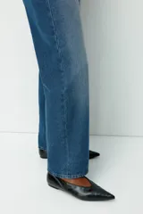 Jean de tiro alto confeccionado en denim rígido, con diseño de cinco bolsillos, cierre con botón y corte de pierna recta levemente holgado.