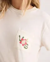 Remera corta de corte boxy en color blanco vintage, con mangas cortas, cuello redondo y un bolsillo aplicado en el pecho que cuenta con un pequeño estampado floral y de serpiente.