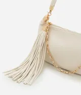 Cartera shoulder de poliuretano color crema, con asa corta de mano y asa larga de cadena dorada, ambas removibles. Incluye cierre de cremallera y borla decorativa.