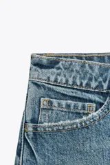 Short de jean de tiro medio, con cinco bolsillos y cierre frontal con cremallera y botón metálico.