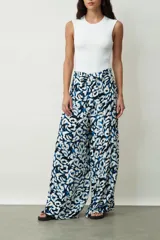 Pantalón ancho de tiro alto con estampado abstracto en tonos blanco, negro y azul. Presenta un lazo en la cintura para anudar.