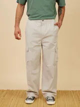Pantalón cargo color beige, de corte holgado y confeccionado en algodón. Cuenta con cintura elástica y bolsillos laterales tipo cargo.