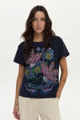 Remera de algodón azul marino de manga corta, con estampa frontal de flores grandes en tonos rosados y motivos geométricos, y detalle de bordado.