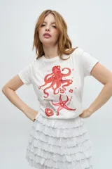 Remera blanca de algodón con cuello redondo y mangas cortas. Estampado frontal con un pulpo, una estrella de mar y una medusa en tonos rosados.