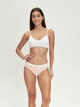 Pack de tres bombachas tipo colaless. Una es blanca lisa, otra es color salmón/rosa pálido con una banda blanca en la cintura, y la tercera es blanca con una banda salmón/rosa pálido en la cintura.