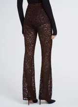 Pantalón largo acampanado de encaje color borgoña con hilos metálicos, cintura alta y cierre lateral invisible.