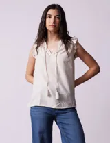 Blusa sin mangas color beige con rayas verticales finas, cuello redondo fruncido con escote en V y lazo con borlas.