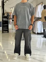 Remera oversize gris con efecto gastado, mangas cortas y estampa con texto blanco en el frente y en la espalda.