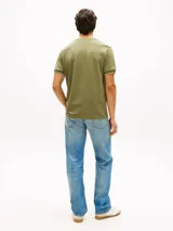 Remera de manga corta Tommy Hilfiger de corte slim en color verde militar, con cuello redondo clásico y detalle de doble raya blanca en los puños. Presenta el icónico logo de la marca bordado en el pecho.