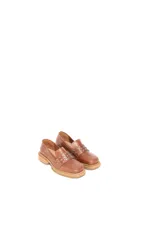 Mocasín de cuero color suela con punta cuadrada y detalle de tachas metálicas en la faja frontal. Cuenta con suela de caucho con vira a la vista.