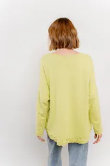 Remera color arena de corte holgado y mangas largas.