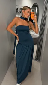 Vestido largo color verde oscuro, de corte strapless con escote recto y falda larga con caída fluida. Incluye una gargantilla a juego.