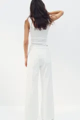 Musculosa corta de ajuste entallado en punto acanalado de algodón, con escote cuadrado y ribete de volados en el cuello y los breteles.