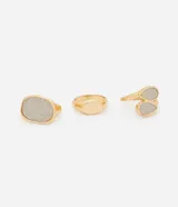Kit de tres anillos de metal dorado con diseños orgánicos. Incluye dos anillos con superficie texturizada brillante y un anillo de diseño liso minimalista.