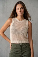 Chaleco tejido sin mangas de calce al cuerpo, con cuello redondo y diseño de punto abierto. Presenta terminaciones acanaladas en cuello, sisas y ruedo.