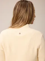 Cardigan de punto color azul, con cierre frontal completo, cuello alto y mangas largas con puños acanalados.