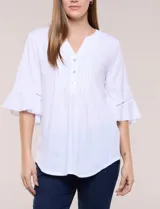 Blusa blanca de crepe crinkle con escote en V, media abotonadura frontal con botones nacarados, alforzas verticales en la pechera y mangas tres cuartos acampanadas con detalle de encaje horizontal.