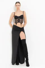 Falda larga negra con abertura alta en la pierna y detalle de fruncido en la cintura.