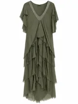 Vestido largo verde militar de corte amplio y fluido, con escote en V ribeteado de pedrería brillante, mangas cortas con volados y múltiples capas de faldones asimétricos con bordes deshilachados.