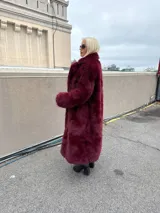 Tapado largo de piel sintética color borgoña, con cuello solapa y bolsillos laterales.