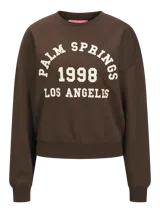 Buzo marrón de cuello redondo con estampado frontal en color blanco que dice "Palm Springs 1998 Los Angeles". De corte relajado y mangas largas con puños elásticos.