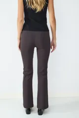Pantalón de tiro medio color gris oscuro, con corte flare, costura central y pequeña abertura en el ruedo. Cierre frontal oculto.