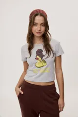 Remera gris melange de manga corta con estampa frontal de pato de goma con labios rojos y turbante, acompañada del texto "WHEN ALL ELSE FAILS TRY DENIAL".