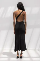 Vestido largo negro de corte al cuerpo, con escote halter y cuello drapeado. Presenta una silueta entallada que se ensancha suavemente hacia el ruedo.