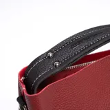Cartera tipo tote bag color rojo con textura granulada, doble asa corta superior y cierre con botón a presión. Incluye monedero negro con cierre de cremallera.