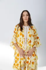 Ruana abierta color crema con estampado de hojas color naranja.