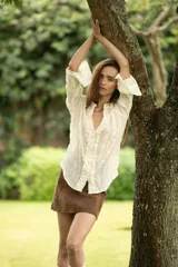 Camisa negra de manga larga con detalle de volados en el frente y puños.