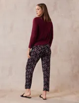 Conjunto de pijama marca René Rofé, compuesto por remera negra de manga larga con bolsillo en el pecho y pantalón largo con estampado animal print, cintura elastizada y lazo de ajuste.