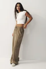 Pantalón cargo de tejido liviano color verde militar, con cintura elástica y cordón ajustable. Presenta diseño de piernas holgadas y bolsillos laterales con solapa.