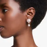 Par de aros colgantes con forma de caracola, bañados en oro rosa y adornados con cristales blancos y una perla colgante.