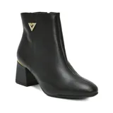 Bota de cuero color beige con taco cuadrado medio y detalle metálico dorado en el talón. Presenta un aplique triangular decorativo con strass en el lateral superior y cierre lateral.