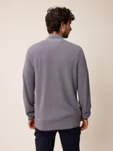 Cardigan de punto gris con cierre frontal completo, cuello tipo mao y puños acanalados. Presenta un pequeño logo bordado en el pecho y detalles en contraste en el interior del cuello y puños.