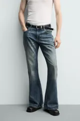 Jeans flare fit de tiro medio, confeccionados en denim de algodón color azul con efecto deslavado. Diseño ajustado en la parte superior y abierto en campana desde la rodilla, con cinco bolsillos y cierre frontal con cremallera y botón.