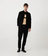 Camisa de hombre color verde oscuro, confeccionada en terciopelo, con cuello clásico, manga larga y dos bolsillos frontales con solapa y botón. Cierre frontal con botones.