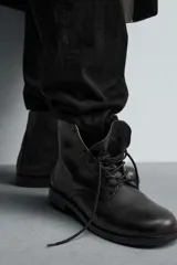 Bota tipo derby con cordones, confeccionada en piel lisa con horma cuadrada y suela con ligero tacón.