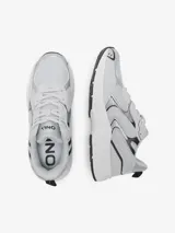 Zapatillas bajas grises con detalles en plateado y negro, con cierre de cordones y suela blanca.